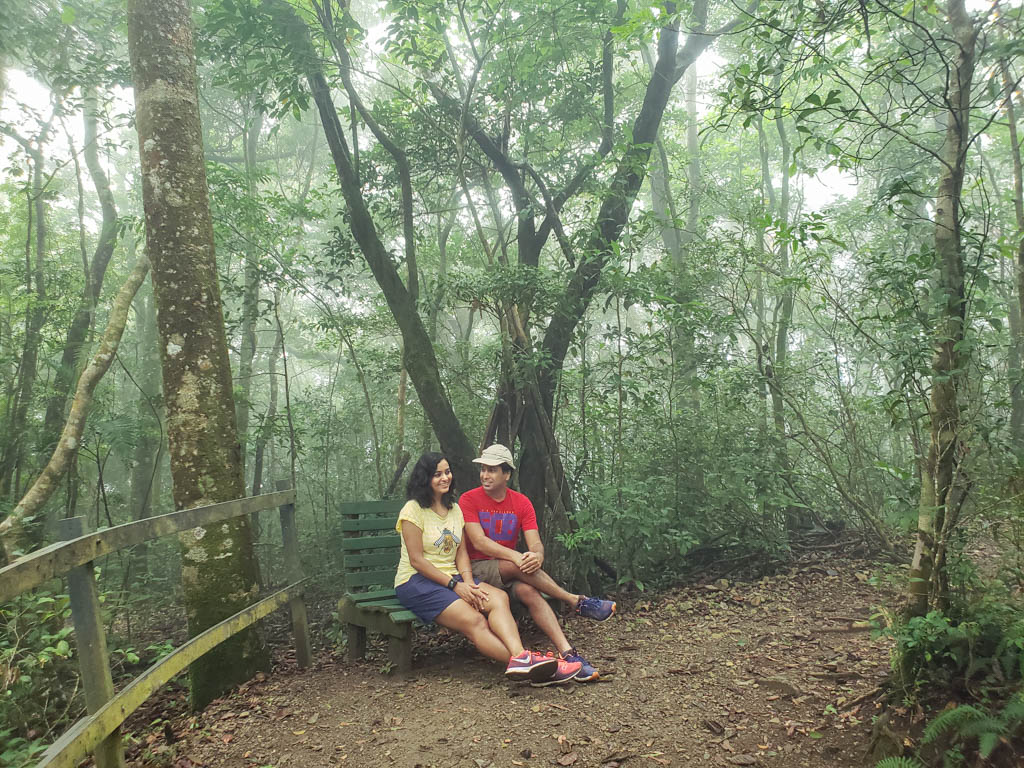 Couple, sitting at one of the benches on the trail at Bajo del Tigre Reserve of Children's Eternal Rainforest.