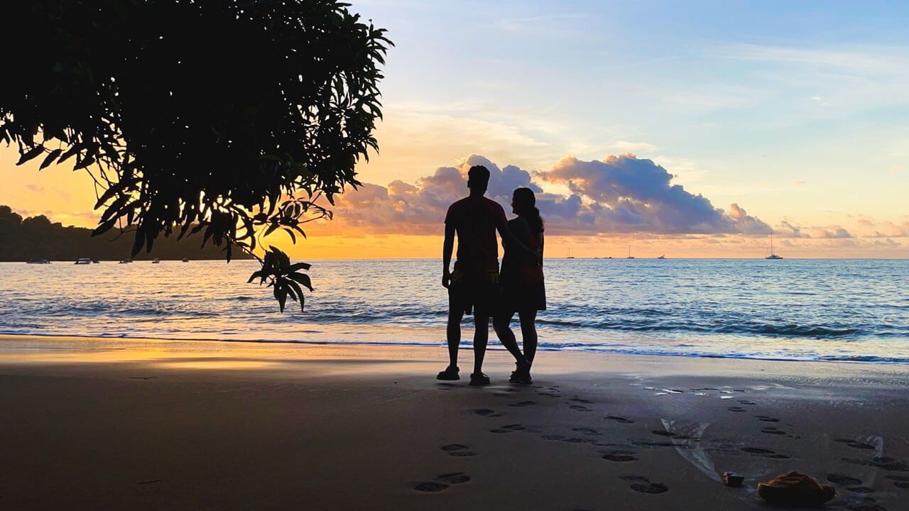 Silhouette of a couple, Paradise Catchers, enjoying the sunset at the beach in Drake Bay, Costa Rica.