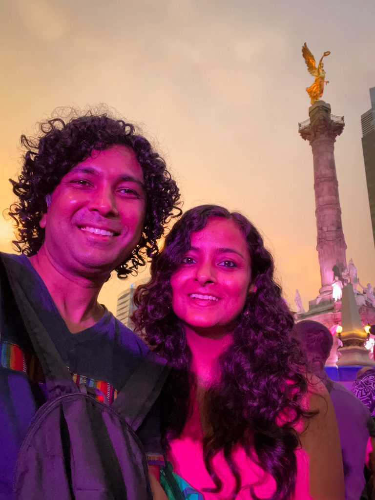 Couple posing for a selfie near Angel de la Independencia in Mexico City, one of the best cities for digital nomads in Latin America.