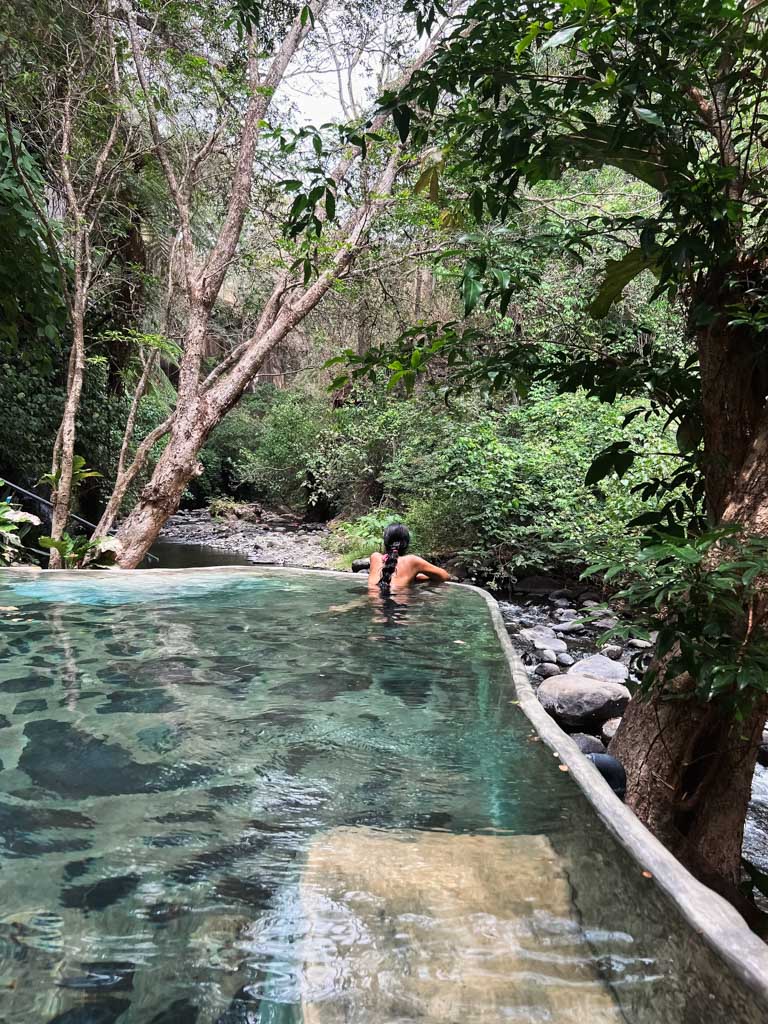 Woman, enjoying the view of the jungle and Tizate river, from the thermal pool at Vandara Hot Springs.