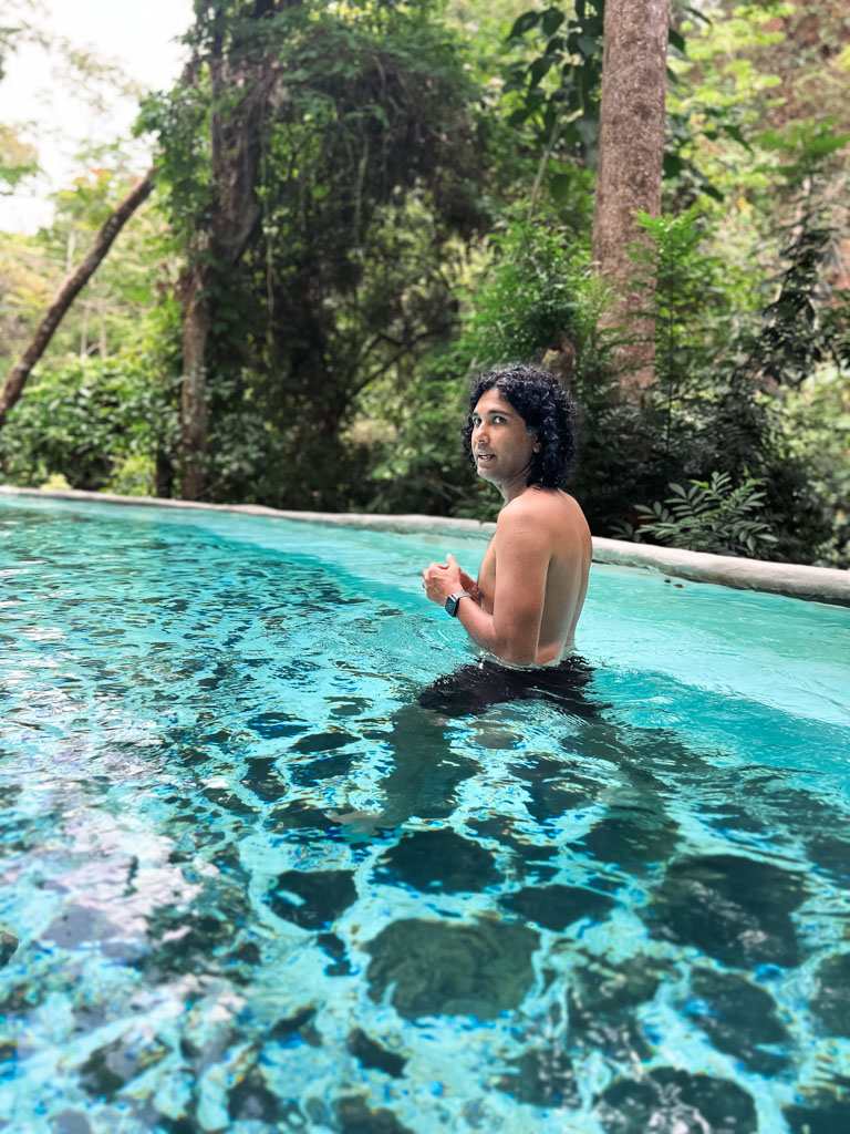 Man, looking for wildlife in the jungle next to the thermal pool at Vandara Hot Springs.