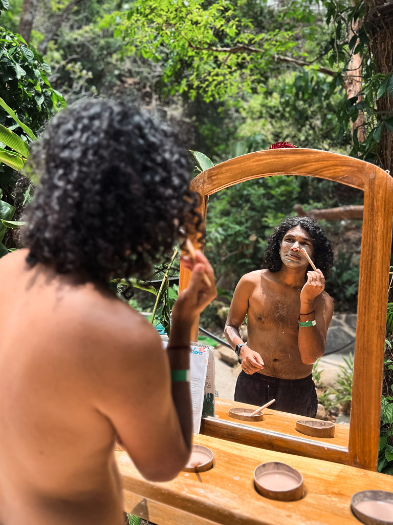 Man, applying volcanic mud on his face as part of the experience at Vandara Hot Springs.