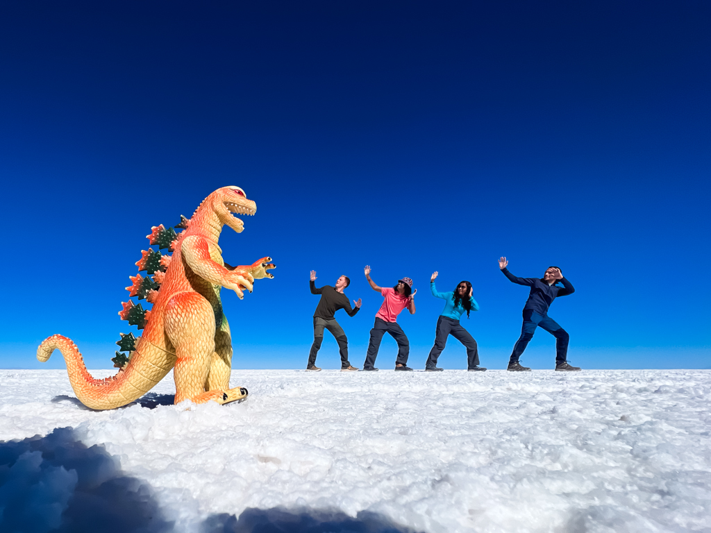 Perspective photo of our group with a dinosaur on our Uyuni Salt Flats Tour.