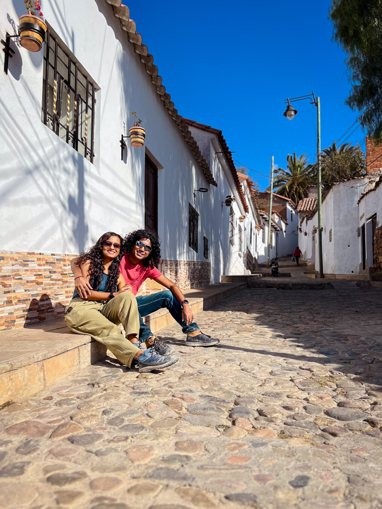 A man and woman sitting on a pavement on Gato Negro Street.