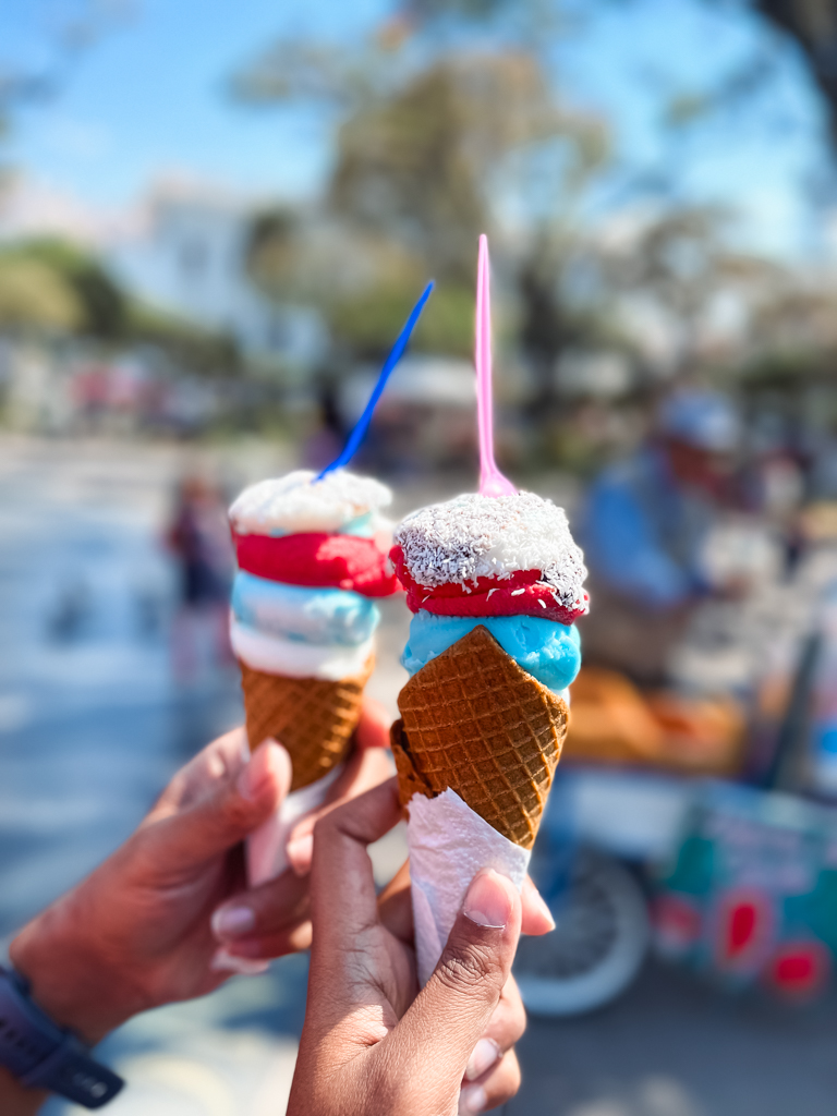 A man and woman's hands holding 2 ice-cream cones 