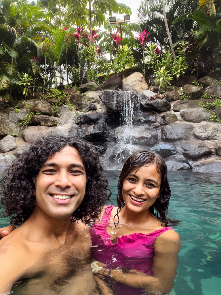 Couple, posing for a selfie, in a thermal water pool in La Fortuna, Costa Rica.