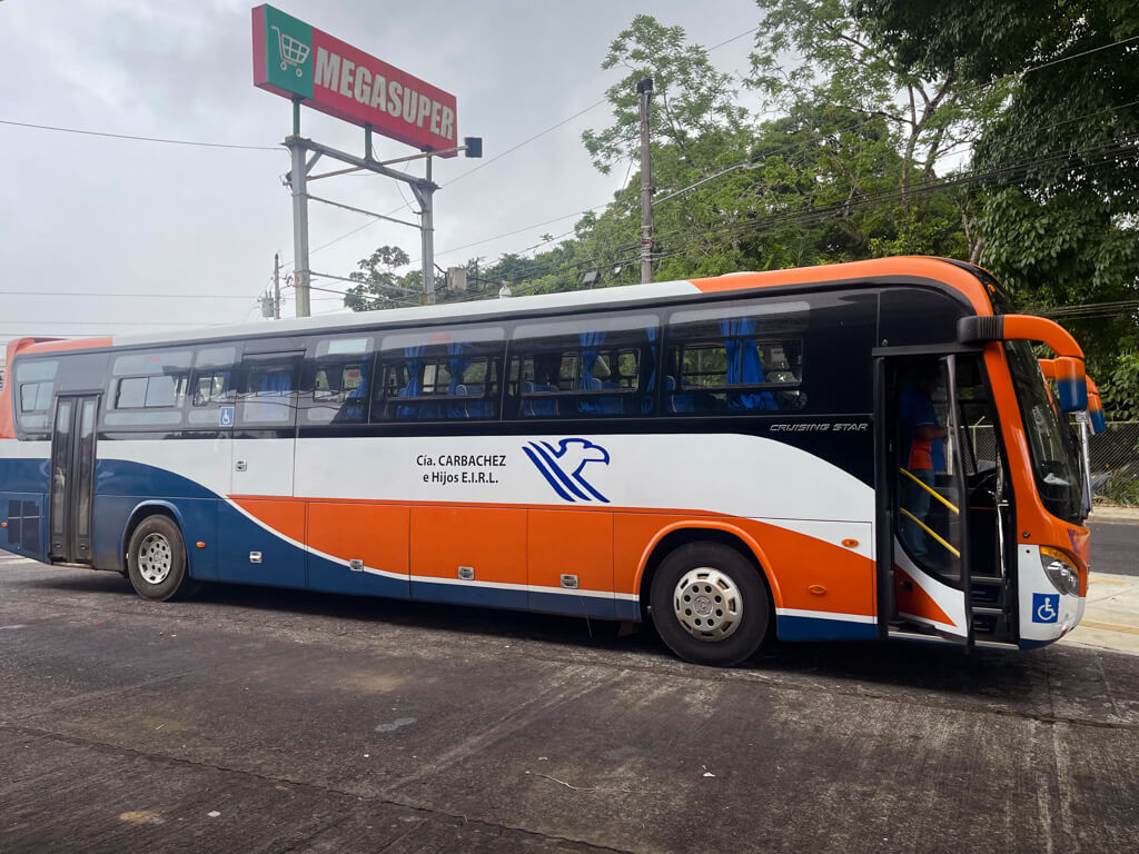 Bus standing next to the Megasuper sign in La Fortuna.