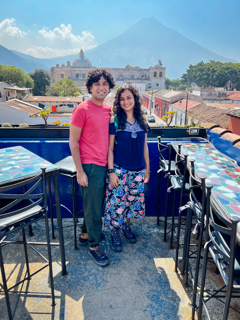 Couple standing at the rooftop of one of the many beautiful cafes in Antigua Guatemala. Volcan Agua in the backdrop.