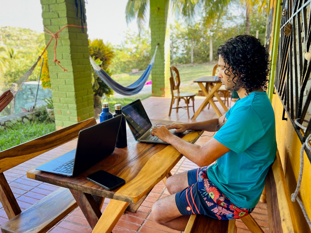 Man, working as a digital nomad in Latin America, at a hostel of a tropical beach destination in Central America.