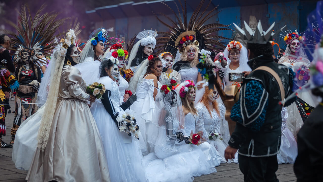 A group of people dressed as Catrinas and Catrins during the Las Catrinas parade for Day of the Dead celebrations in Mexico City.