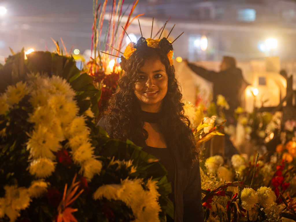 Woman standing amidst the Day of the Dead decorations at the cemetery in Mixquic.