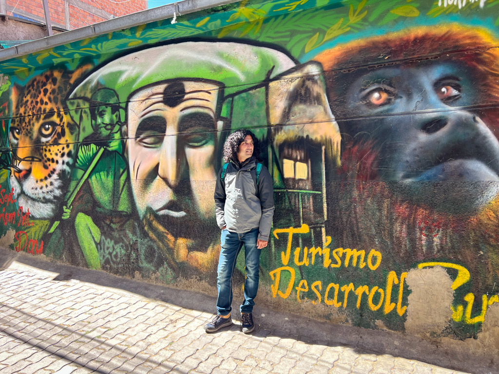 Man standing against a graffiti wall in the Zona Centro of La Paz, Bolivia.