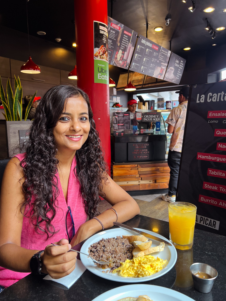 A woman with a plate of Gallo Pinto, the typical breakfast dish of Costa Rica.