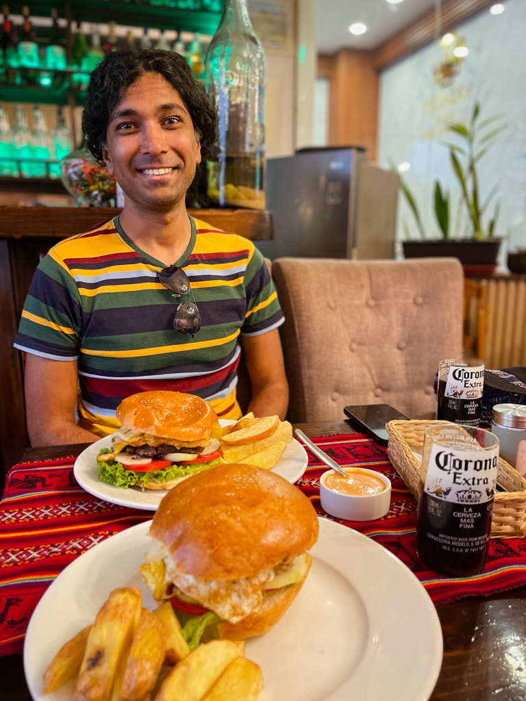 Man and plates of burgers and fries.