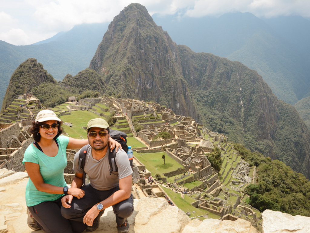 Couple posing with the classic view while visiting Machu Picchu.