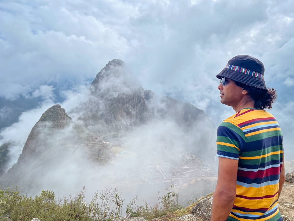 Man enjoying the views of Machu Picchu covered in clouds.