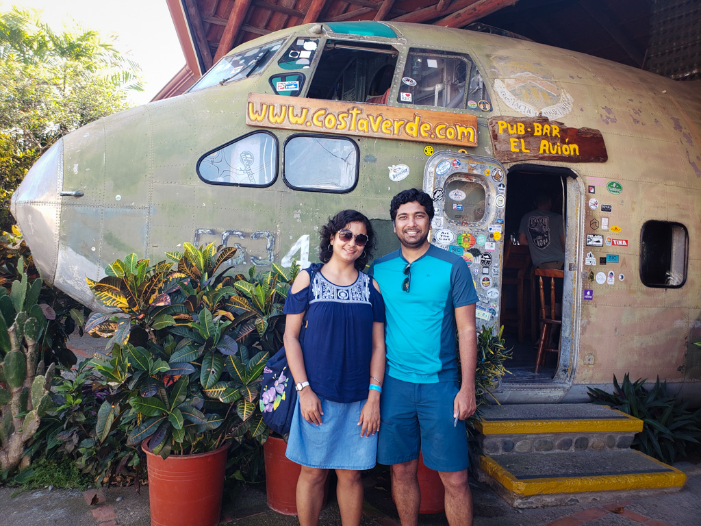 Couple standing next to the El Avion plane restaurant in Manuel Antonio.