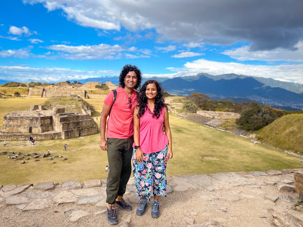 Couple standing on top of one of the pyramids at Monte Alban - an easy side trip to include in an Oaxaca Mexico itinerary.